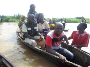 Les facilitateurs traversent à pirogue la rivière Mutambala (en t-shirt rouge : Mr Sumaili et en t-shirt beige Mme Judith Mugoli)